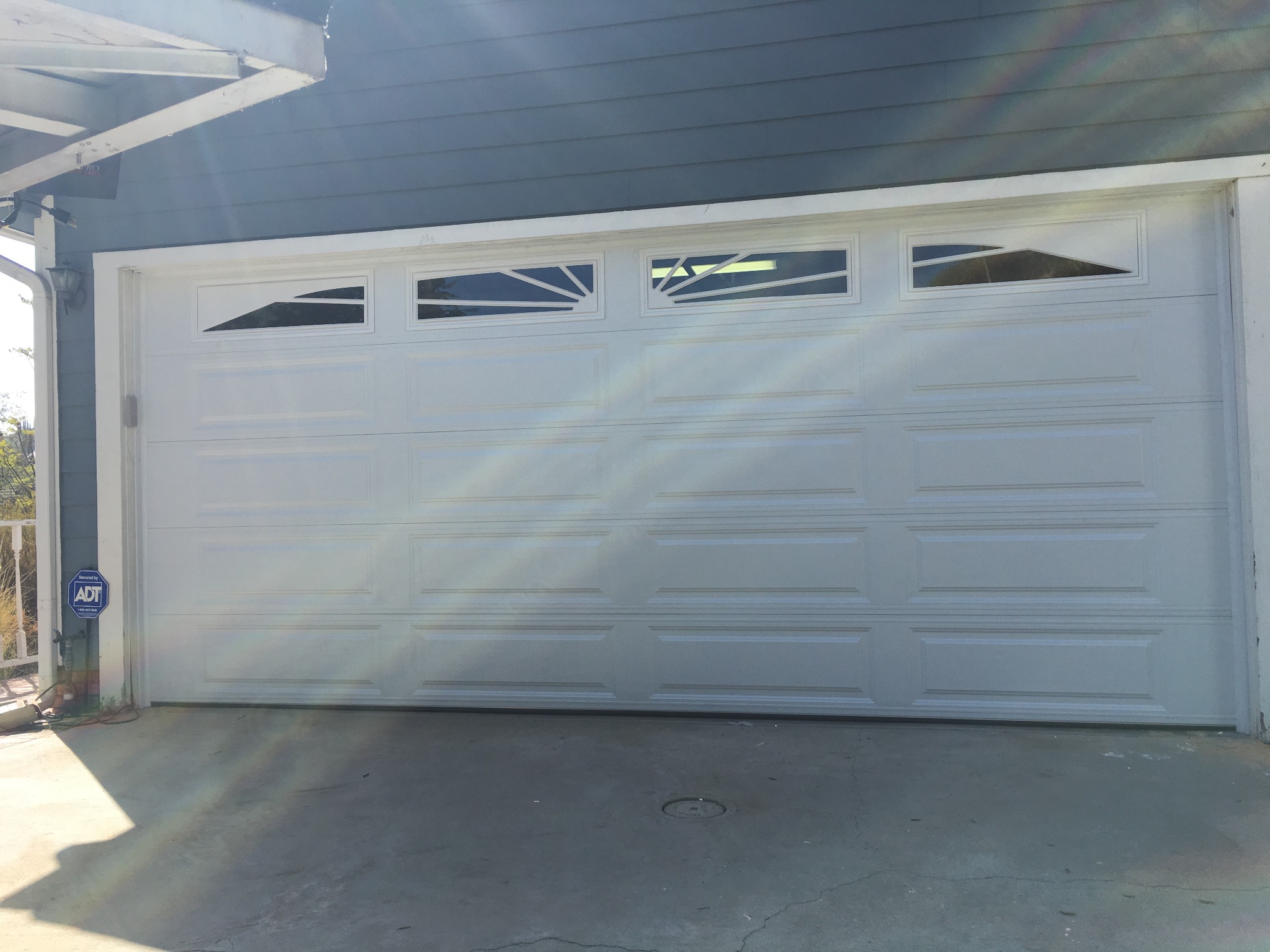 White garage door with decorative sunburst windows
